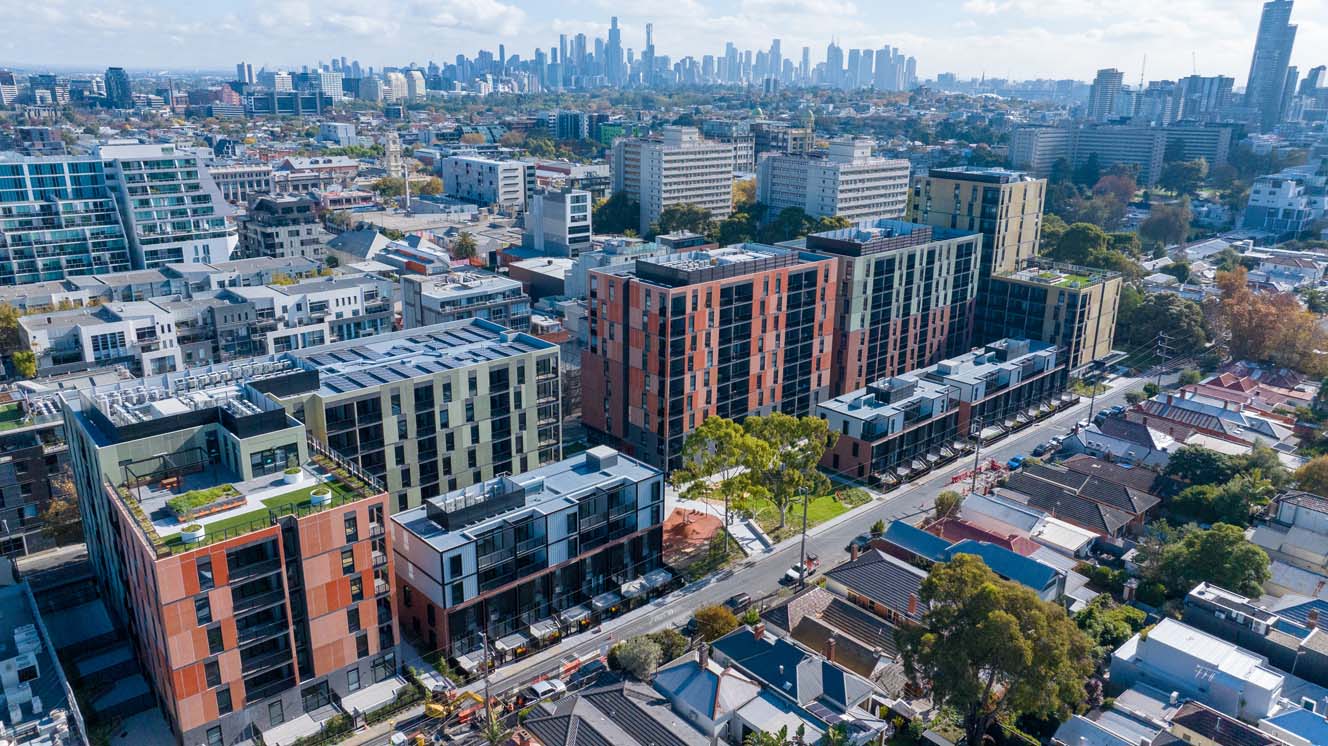 Drone image of the Bangs Street housing development surrounded with green trees, oval and local community