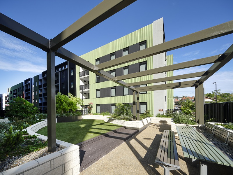 Pergola with a new apartment building in the background