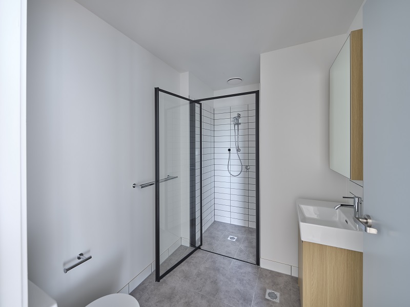 Modern bathroom with vanity, sink, walk-in shower and toilet