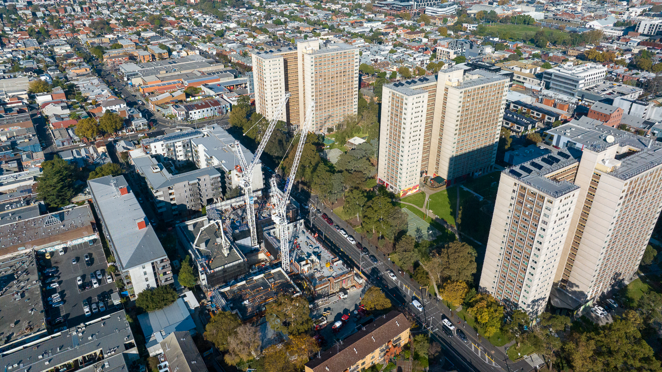 Aerial image of a construction site with 2 cranes opposite 3 tower blocks